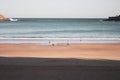 Unknown people walking on the beach called La Concha. Bay of Biscay in San Sebastian in autumn. Wide aerial beach in morning. Royalty Free Stock Photo