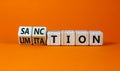 Sanction and limitation symbol. Turned wooden cubes and changed the word limitation to sanction. Beautiful orange table, orange