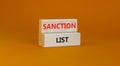 Sanction list symbol. Wooden blocks with concept words Sanction list on beautiful orange background. Business political sanction