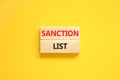 Sanction list symbol. Wooden blocks with concept words Sanction list on beautiful yellow background. Business political sanction