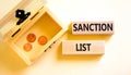 Sanction list symbol. Wooden blocks with concept words Sanction list on beautiful white background. Wooden chest with coins.