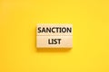 Sanction list symbol. Wooden blocks with concept words Sanction list on beautiful yellow background. Business political sanction