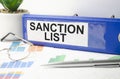 sanction list words on blue folder and charts