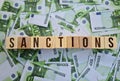 Sanction text on cubes on euro banknotes. EU economic sanctions