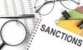SANCTIONS - the inscription of text on the Notepad, and chart. Business concept Royalty Free Stock Photo