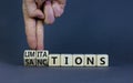 Sanctions or limitations symbol. Businessman turns cubes, changes the word sanctions to limitations. Beautiful grey table, grey