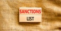 Sanctions list symbol. Wooden blocks with concept words Sanctions list on beautiful canvas background. Business political