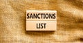 Sanctions list symbol. Wooden blocks with concept words Sanctions list on beautiful canvas background. Business political