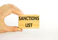 Sanctions list symbol. Wooden blocks with concept words Sanctions list on beautiful white background. Businessman hand. Business