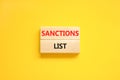 Sanctions list symbol. Wooden blocks with concept words Sanctions list on beautiful yellow background. Business political