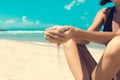 Sand as the time slips through your fingers. Girl holding a sand sea background. Concept of vacation in warmer climes Royalty Free Stock Photo