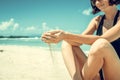 Sand as the time slips through your fingers. Girl holding a sand sea background. Concept of vacation in warmer climes Royalty Free Stock Photo