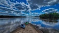 Kayaks along a sandbar near Spring Green on the Wisconsin river with clouds reflecting in the water
