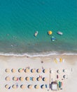 Sand beach aerial view, vertical shot. Sunbeds, sunshades and water sports equipment, people swimming and taking sunbath Royalty Free Stock Photo