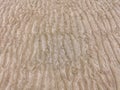 Sand on the beach for background. Brown beach sand texture. Close-up sand pattern. Top view wavy sand background for summer design