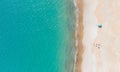 Sand beach with few people taking sunbath and calm sea. Aerial view directly above