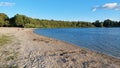 Sand beach at lake with forest on shore line Royalty Free Stock Photo