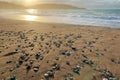 Sand beach with pebbles and tranquil sea water and bright sunset over mountains Royalty Free Stock Photo