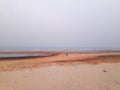 Sand beach of Puri, India with a wide horizon and one person with a child walking far away