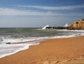 Sand beach with rough sea waves and beautiful sandstone cliffs a Royalty Free Stock Photo