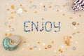 Sand on the beach in summer, the inscription enjoy from the shells on the sand. Flat lay. Top view Royalty Free Stock Photo