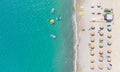 Sand beach with sunbeds, sunshades and water sports equipment, people swimming and taking sunbath. Aerial view directly above Royalty Free Stock Photo