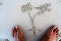 Sand bubbler crab beach pattern in palm form with human feet on white thailand beach Royalty Free Stock Photo