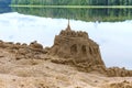 Sand building on the beach, sand castle on the shore of the pond