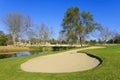 Sand bunker on the golf course with trees and pond Royalty Free Stock Photo