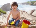 Sand castle, beach and portrait of child with bucket and toys on summer holiday, vacation and relax by ocean. Childhood Royalty Free Stock Photo