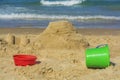 Sand castle and buckets on beach Royalty Free Stock Photo