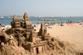 Sand castle and sunbathing people