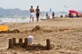 Sand castle and tourists on Spanish beach