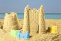 Sand castles with toys on ocean beach. Outdoor play Royalty Free Stock Photo