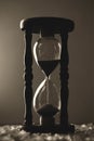 Sand clock on broken glass pieces in blur. Royalty Free Stock Photo