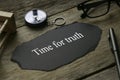 Sand clock, compass, pen, glasses and a piece of black paper written with Time For Truth on wooden background Royalty Free Stock Photo