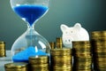 Sand clock, piggy bank and money. Bank deposit and savings