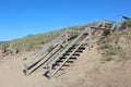 A stairway over high sand dunes on the beach at Inverness Nova Scotia on a sunny day. Royalty Free Stock Photo