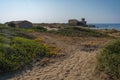 Sand dunes in the background of the medieval castle in Torre Astura in Lazio, Italy