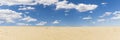 Sand dunes and blue sky with white clouds Royalty Free Stock Photo