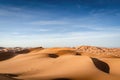 Sand dunes. Desert landscape. Erg Chebbi in Morocco. Sahara desert. Vast desert landscape with endless dunes and blue sky in the