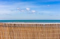 Sand dunes fence at beach with sea water and sky background Royalty Free Stock Photo