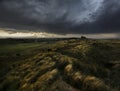 Sand Dunes with grasses and dark stormy sky`s Royalty Free Stock Photo