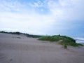 Sand Dunes hill white beach Green grass, and bright blue sky Royalty Free Stock Photo