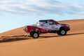 On sand dunes in Lut desert with a dakar edition race car