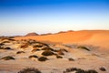 Sand dunes, mountains and scrub at sunset Royalty Free Stock Photo