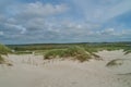 Sand dunes and green hinterland of Nymindegab Strand, Denmark under vivid sky Royalty Free Stock Photo