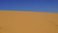 Sand dunes with sand ripples and clear blue sky. Travel background with sand meets sky Royalty Free Stock Photo