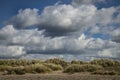 Sand dunes underneath a blue cloudy dramatic sky. Royalty Free Stock Photo