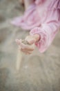 Sand falling through the fingers of a woman`s hand. Royalty Free Stock Photo